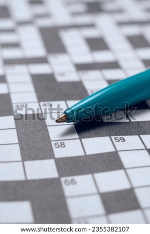 Ballpoint pen is lying on piece with crossword puzzle.Hobby concept and mental recreation