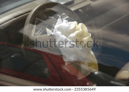 Airbag after road collision, front impact, deployed airbag on steering wheel, driver protection. Blown up airbag after car crash, road accident. 
 Royalty-Free Stock Photo #2355385649