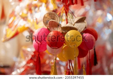 Decorated colorful lanterns hanging on a stand in the streets in Ho Chi Minh City, Vietnam during Mid Autumn Festival. Chinese language in photos mean money and happiness. Selective focus.