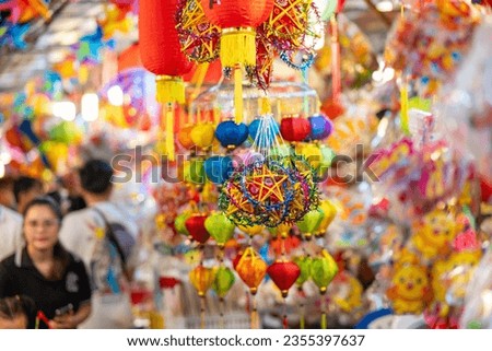 Decorated colorful lanterns hanging on a stand in the streets in Ho Chi Minh City, Vietnam during Mid Autumn Festival. Chinese language in photos mean money and happiness. Selective focus.