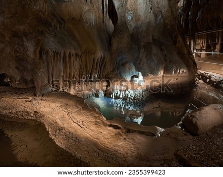 Inside of the cave with stalagmite formations. Subterranean rivers flowing through the cave system.

Portrait orientation photo at "Jama Pekel cave" in Slovenia.