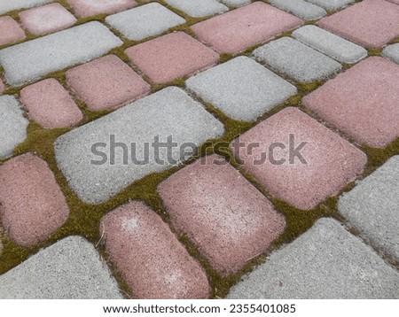 Beautiful paving (playground or path) of gray and pink, red paving slabs.