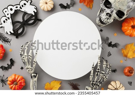 Halloween party idea. Top view photo of halloween eyewear, skull, skeleton hands, pumpkins, autumn leaves, creepy insects on grey background with blank circle for promotion or content