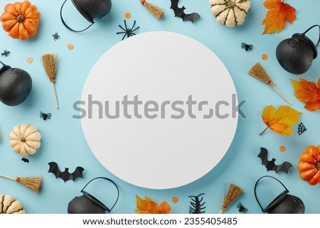 Decor with the supernatural energy of Halloween. Top view photo of brooms, witchcraft pots, pumpkins, autumn leaves, creepy insects on light blue background with blank circle for ad or text