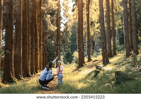 Mother child in the woods learning about nature Royalty-Free Stock Photo #2355415223