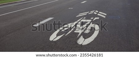 White sign painted on a road surface designating a lane for sharing between cars and bikes