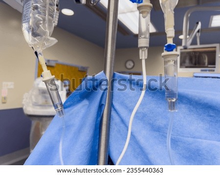Medical supplies including syringes, IV drips, and drug vials symbolize hospital care. Anesthetics, vasopressors, and narcotics convey treatment and sedation
