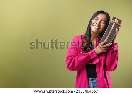 Expression happy beautiful young asian woman smile with black gift box isolated on green background. Teenage girls in love, Receiving gifts from lovers. New Year, and Valentines Day concept