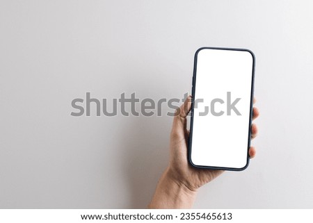 Hand of caucasian woman holding smartphone with blank screen and copy space on white background. Cyber technology, electronic device and communication concept.