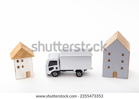 A model house and a truck on a white background.