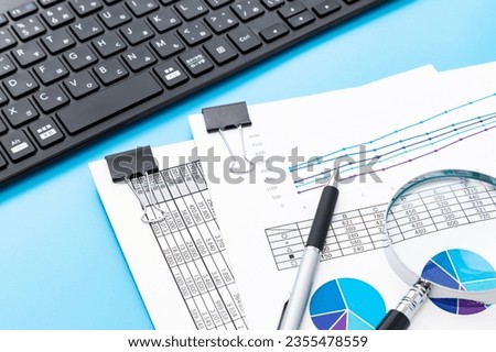 Work documents and computer on blue background.
Translation:year, kana, romaji, conversion, non-conversion, company