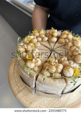 Woman holding plate with delicious Caramel Macadamia Coffee Birthday Cake Isolated On White With No People. Cake on wooden plate. Bakery picture free space for text. Menu cafe and coffee shop.