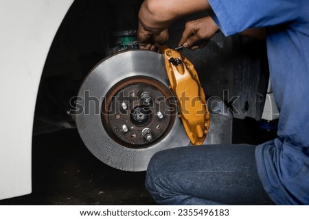 Car brake fluid bleeding service in garage service shop. Royalty-Free Stock Photo #2355496183
