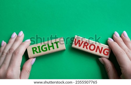 Right or Wrong symbol. Concept word Right or Wrong on wooden blocks. Businessman hand. Beautiful green background. Business and Right or Wrong concept. Copy space