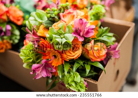 gerbera, tulips and mix of summer flowers bouquet for the wedding in the Florida. Orange roses, lily and gerbera flowers bouquet in the brown box getting ready for delivery  Royalty-Free Stock Photo #235551766