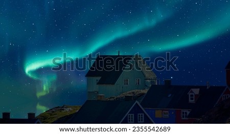 Picturesque village on coast of Greenland - Colorful houses in Tasiilaq with Aurora Borealis or Northern lights - East Greenland Royalty-Free Stock Photo #2355542689