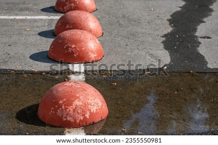 Red concrete pillars in the parking lot.