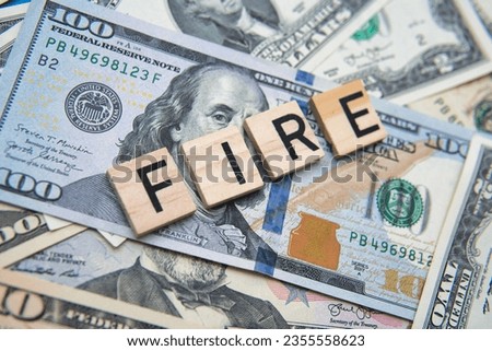 the inscription FIRE or Financial Independence, Retire Early against the background of American dollars