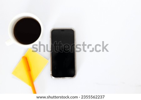 Work desk with coffee, pen, notebook, white background phone with space for text.