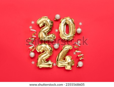 Composition with figure 2024 made of golden foil balloons and Christmas decorations on red background