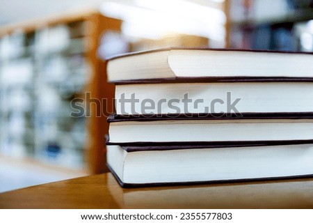 Library with four books stacked on desk