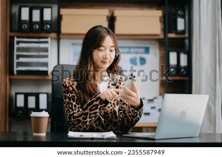 Young beautiful woman using laptop and tablet while sitting at her working place. Concentrated at work.