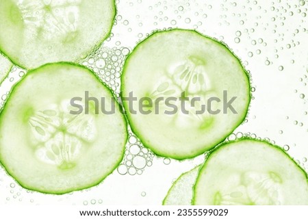 sliced cucumbers float on the surface of the water Royalty-Free Stock Photo #2355599029
