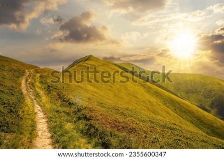 mountain landscape at sunset. traverse path through grassy hillside to the mountain top. beautiful nature scenery with steep slopes in evening light Royalty-Free Stock Photo #2355600347