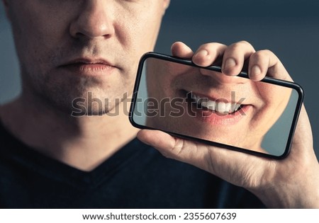 Fake social media smile or filter. Sad face and happy in phone screen. Mental health, depression online and technology concept. Man with anxiety. Image and photo edit. Pressure and emotion.
