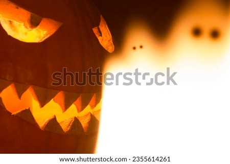 Spooky carved halloween pumpkin and creepy mystery fire ghosts. Big helloween autumn symbol with mad face, glowing eyes, mouth and teeth. Scary hot nightmare horror with evil smile at october 31st