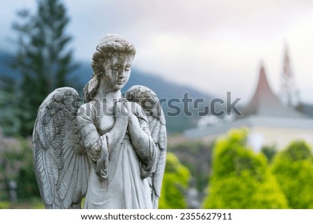 Close up of angle statue stone white art decorating in the big garden on soft sunlight and nature background.