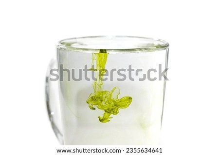 Green color of tea drops in the water glass look great and artificial.concept photo art of watermark.