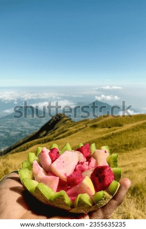 Fresh fruit in hand with Mount Sindoro and Sumbing in the background