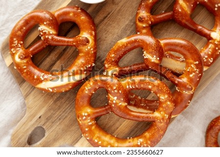 Homemade Soft Bavarian Pretzels with Mustard on a wooden board, top view. Royalty-Free Stock Photo #2355660627