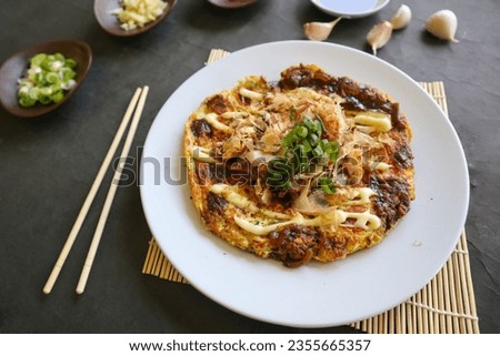 okonomiyaki, Traditional Japanese Pizza, Japanese hot plate pizza from Okonomiyaki. made of flour which is diluted with water or dashi, plus cabbage, chicken eggs, seafood and fried in a teppan