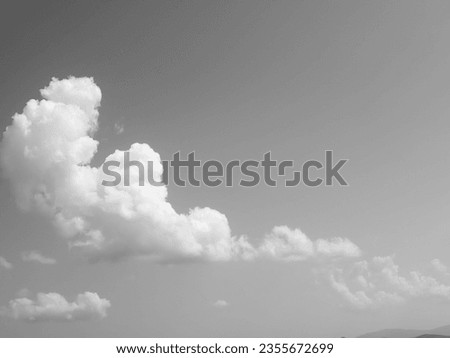 High cumulus clouds paint the sky in monochrome strokes, a celestial canvas of serene grandeur. Nature's whispers echo in their billowy embrace Royalty-Free Stock Photo #2355672699