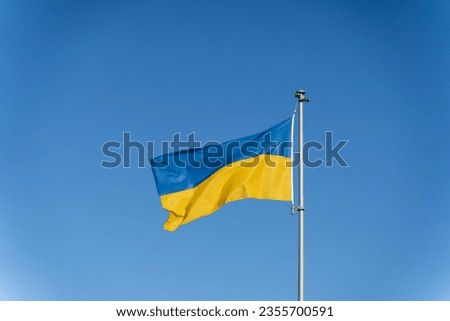 Ukrainian flag of yellow-blue colors on the background of clear blue sky.