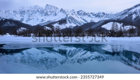Frozen lake with beautiful reflections of the snow mountains on sunrise and sunset. High resolution.