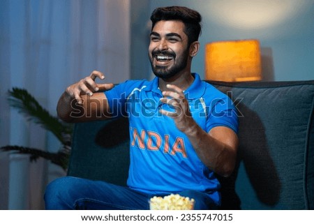 Emotional Young man Celebrating Indian cricket team victory while watching on tv at home - concept of Winning Happiness, Emotional moments and entertainment.