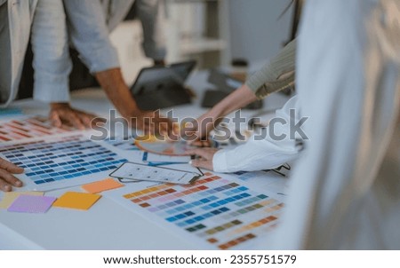 Startup team collaborate to select colors for new products. Optimizing user experience. Brainstorming, communicating to ensure innovative and scalable prototypes meet real user requirements. Royalty-Free Stock Photo #2355751579