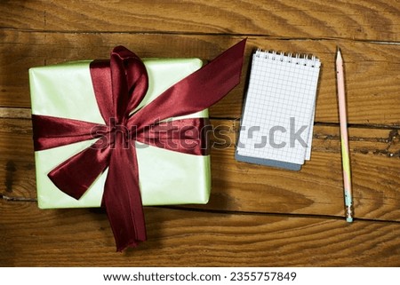 gift box for christmas and empty  notebook on wood table