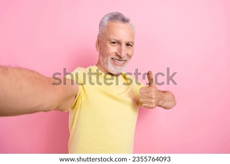 Portrait of satisfied nice retired person wear stylish t-shirt showing thumb up approve doing selfie isolated on pink color background