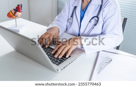 Cardiologist supports the heart senior asian woman doctor wearing glasses and uniform. portrait of mature old asian woman medic professional.