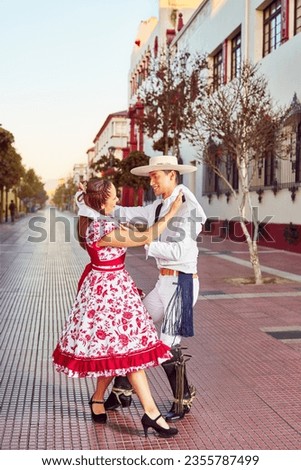 portrait young couple dressed as huaso dancing cueca in the city street Royalty-Free Stock Photo #2355787499