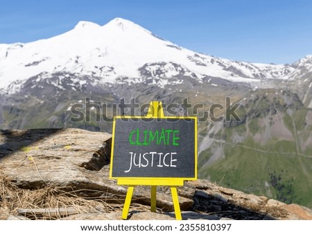Climate justice symbol. Concept words Climate justice on beautiful black chalk blackboard. Chalkboard. Beautiful mountain Elbrus background. Business environment climate justice concept. Copy space.