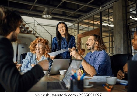 Young and diverse group of coworkers working on a project and having a meeting in a startup company office Royalty-Free Stock Photo #2355831097
