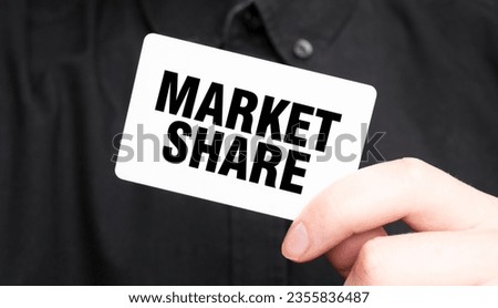 Businessman holding a card with text MARKET SHARE, business concept