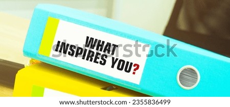 Two office folders with text WHAT INSPIRES YOU