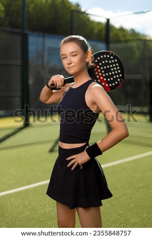 Padel tennis player with racket. Girl athlete with paddle racket on court outdoors. Sport concept. Download a high quality photo for the design of a sports app or web site.