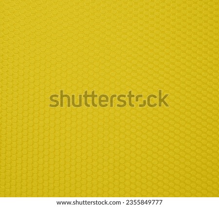 A yellow background texture made up of small hexagons that are slightly convex. The hexagons are arranged in a repeating pattern. The color is bright, warm yellow.